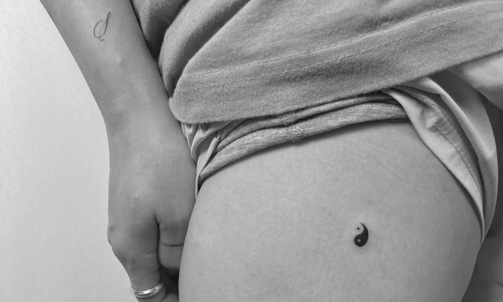 Minimalistic style Yin Yang tattoo located on the hip.