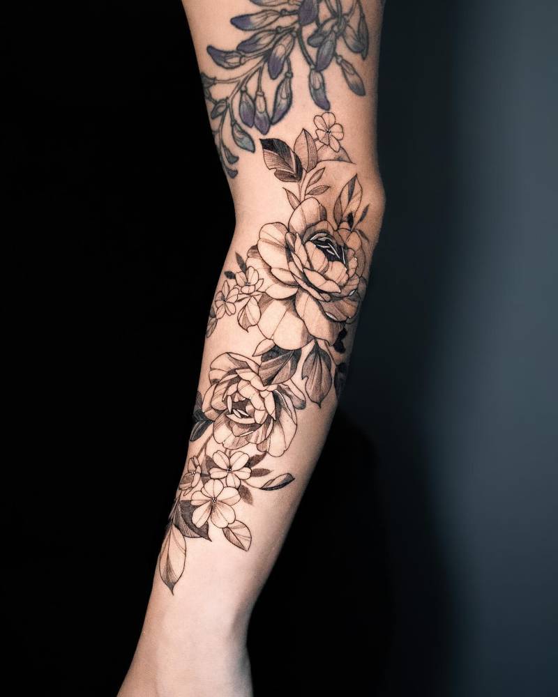 Illustrative style peony flowers tattooed on the forearm.
