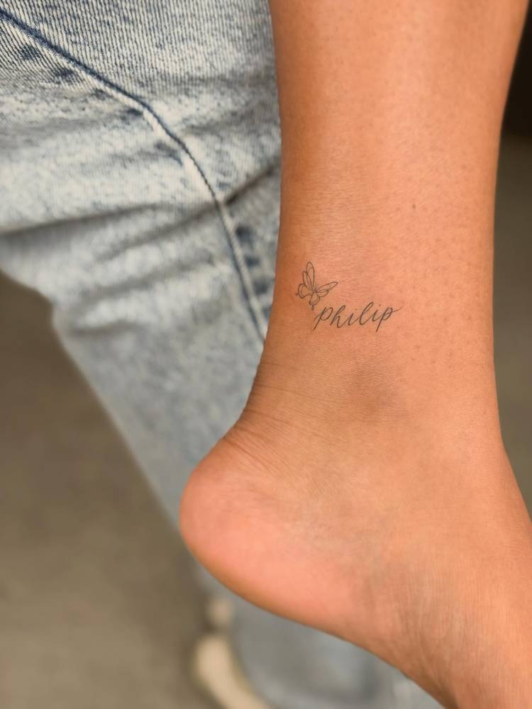 Name "Philip" and butterfly tattoo located on the ankle.