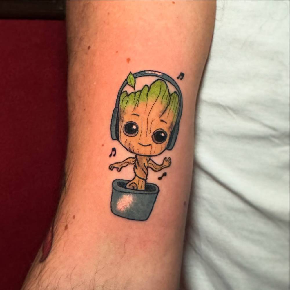 Hand poked Groot tattoo in cartoon style placed on the bicep.