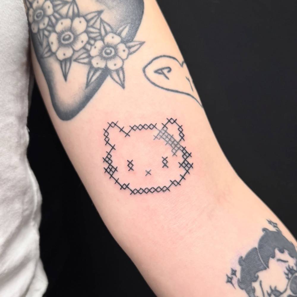 Cross stitch style Hello Kitty tattoo located on the inner arm.