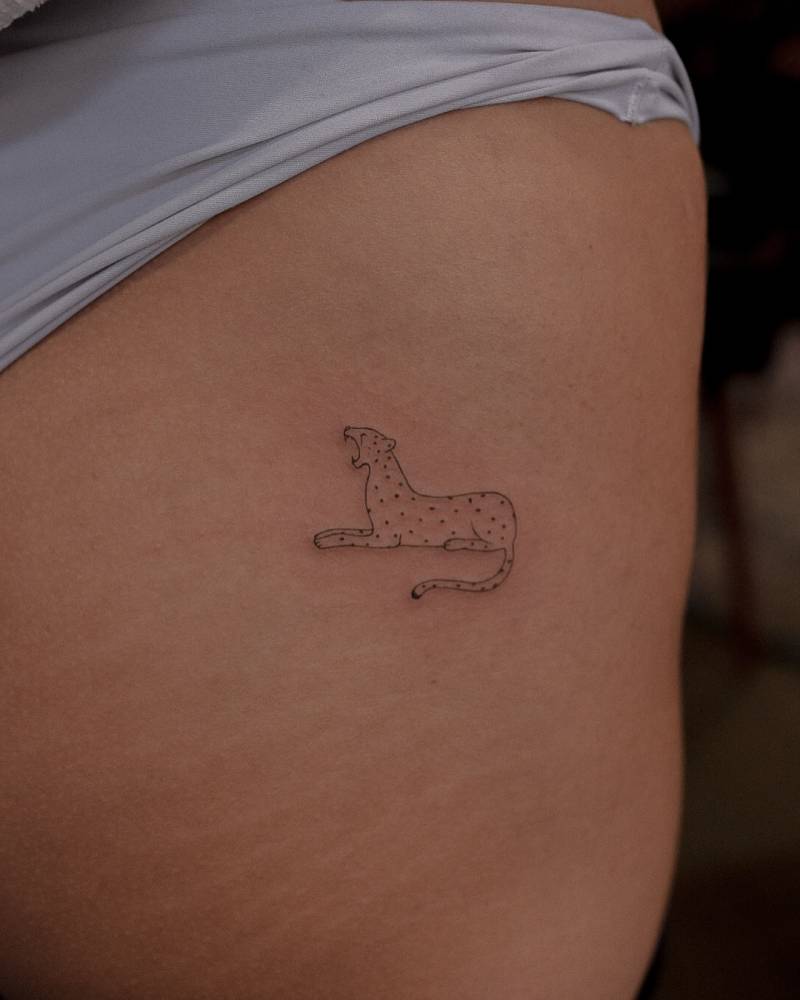 Fine line style cheetah tattoo located on the hip.