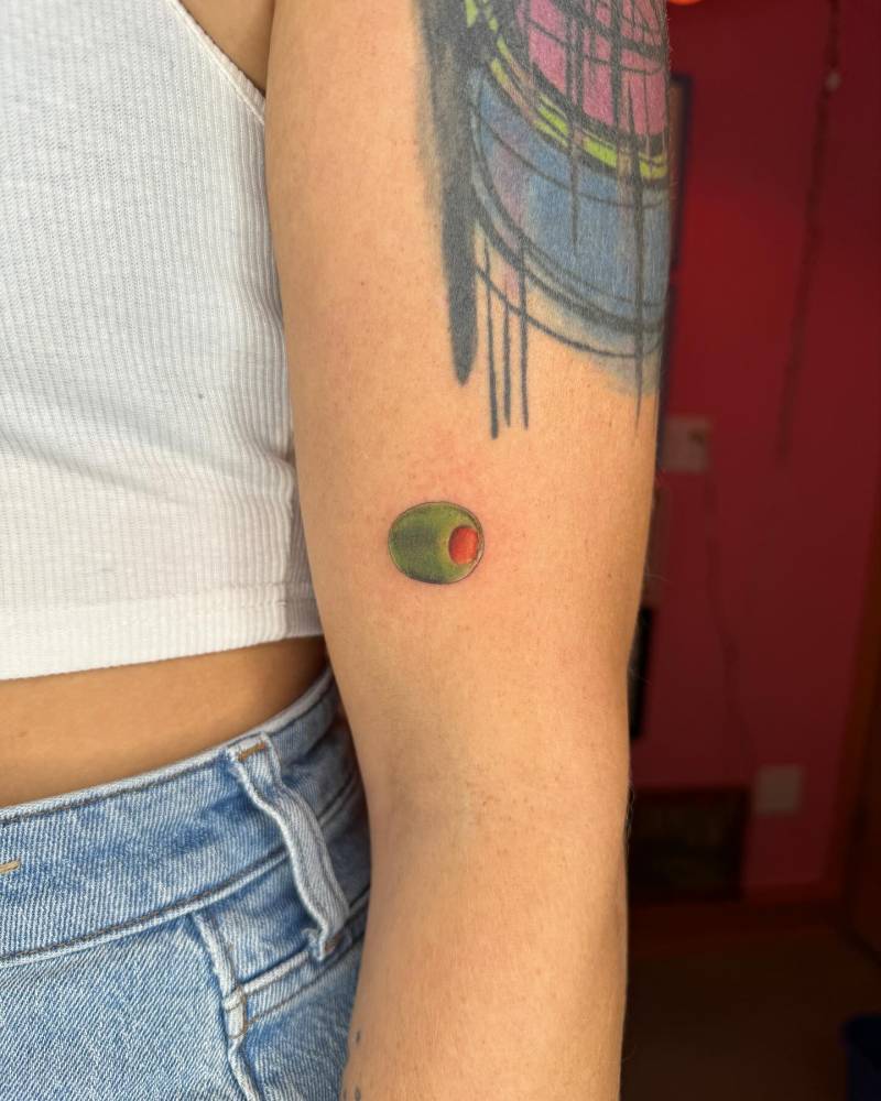 Olive tattoo in illustrative style located on the upper arm.