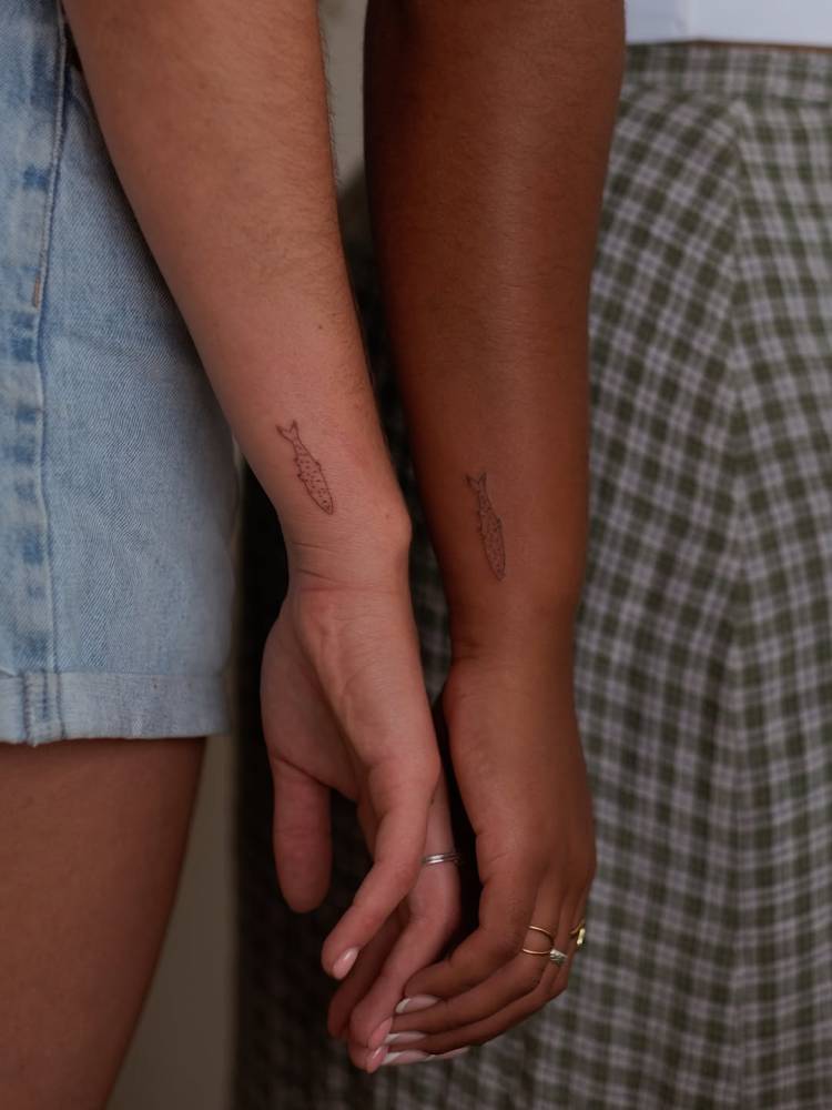 Matching fine line style fish tattoo for best friends.