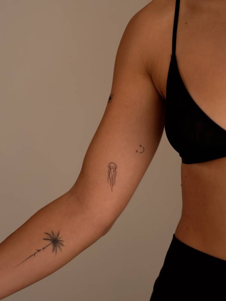 Tiny fine line jellyfish tattoo placed on the inner arm.