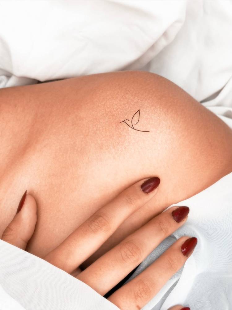 Minimalistic style Tatteco logo tattoo located on the shoulder.