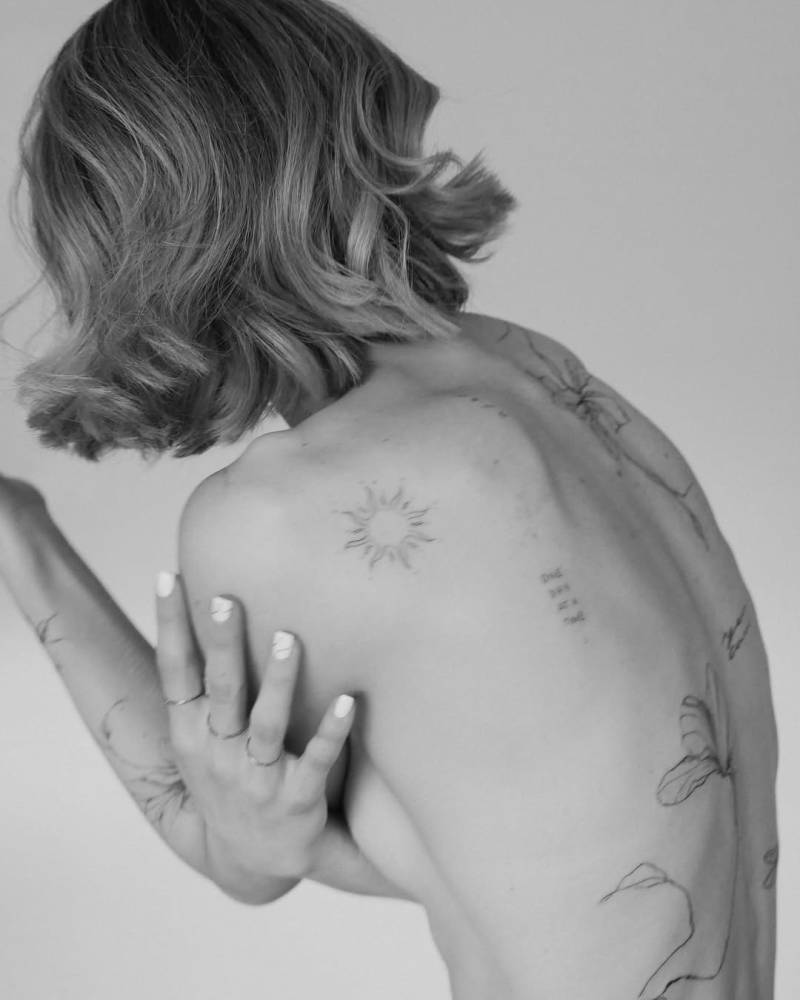 Sun tattoo in fine line style located on the shoulder blade.