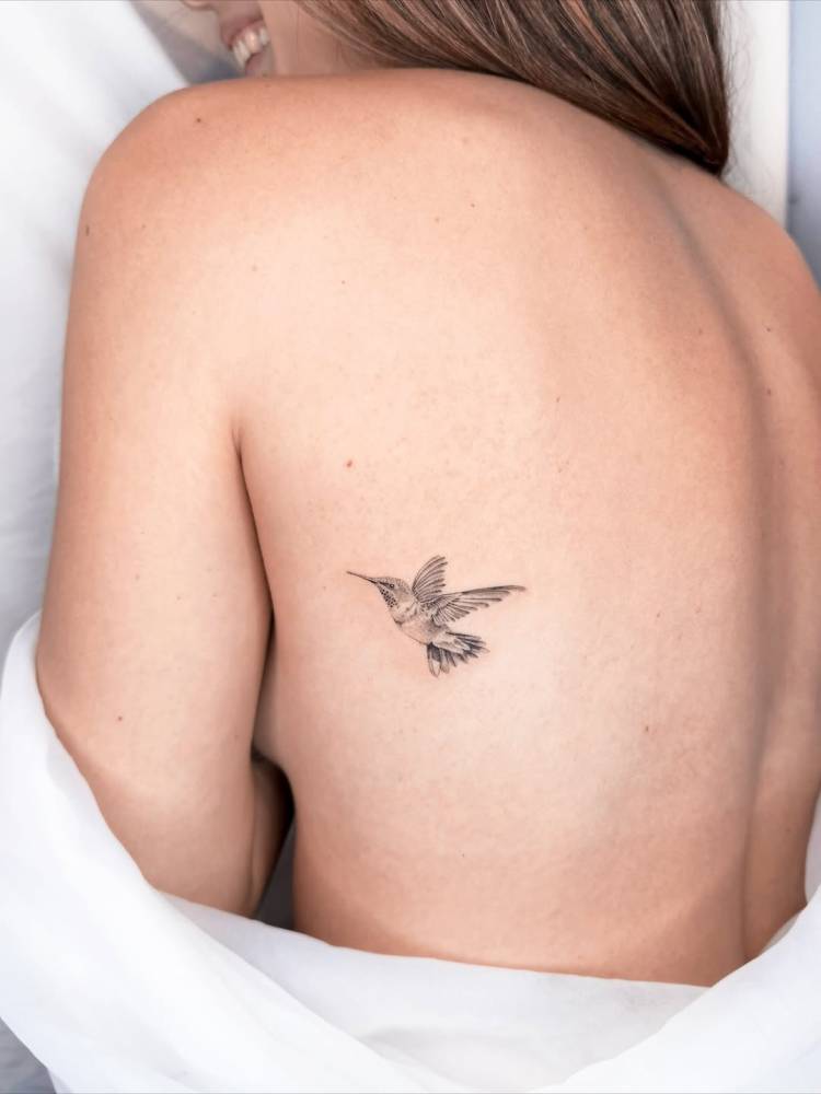Hummingbird tattoo in micro-realistic style located on the back.
