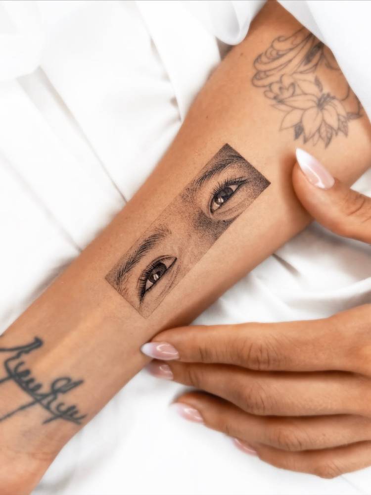 Eyes tattoo located on the inner forearm, done in micro-realistic style.
