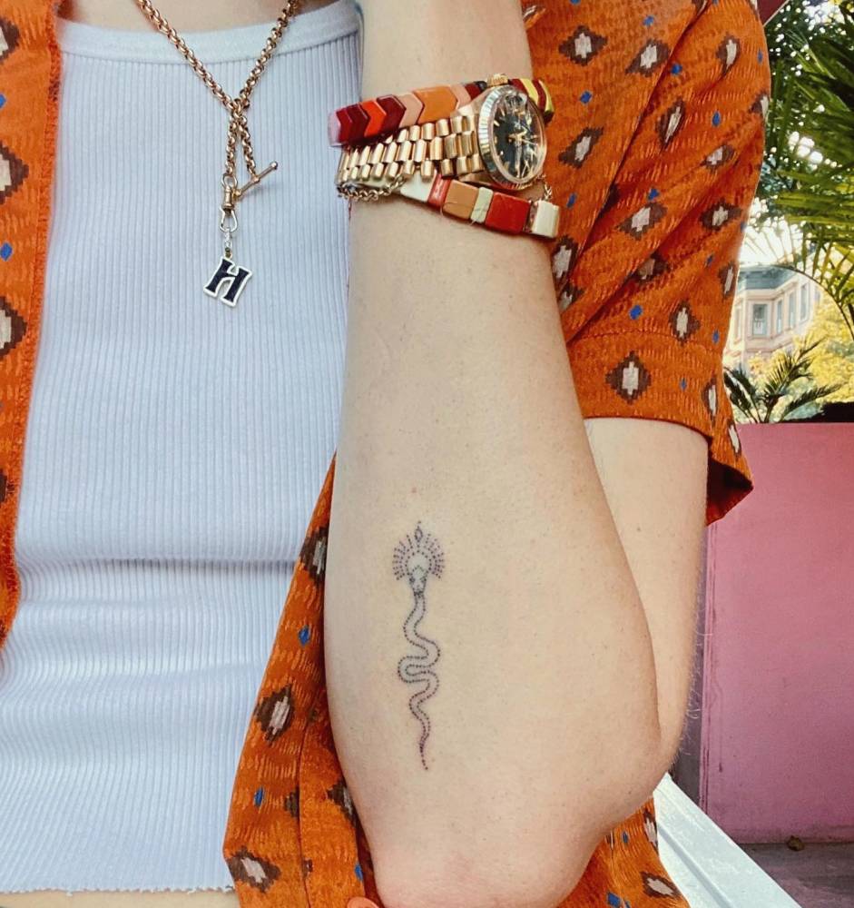 Hand poked style snake tattoo located on the forearm.