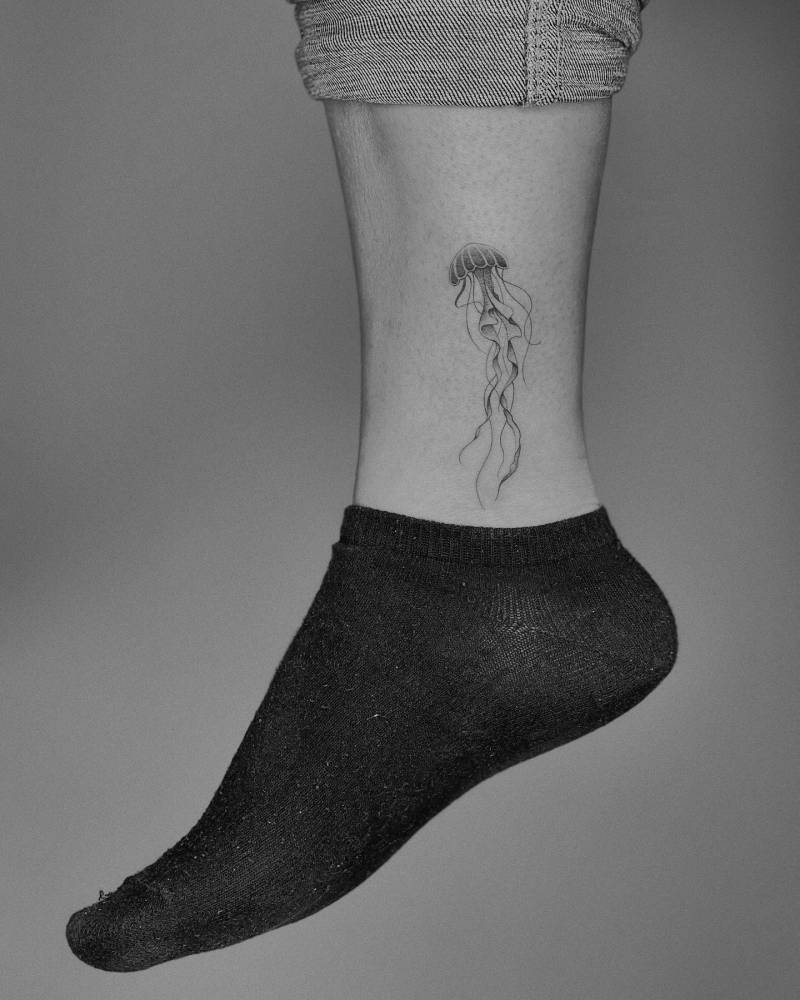Jellyfish tattoo in illustrative style placed on the ankle.