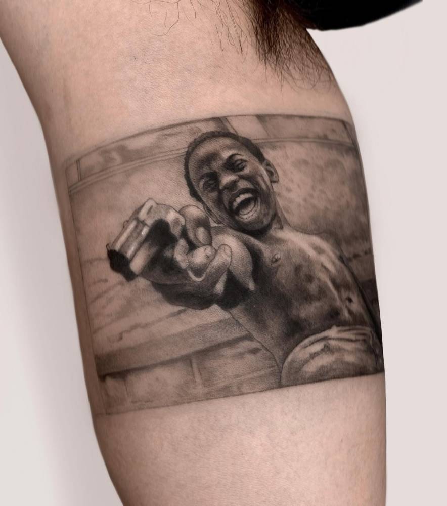 Zé Pequeño. Micro-realistic style 'City of God' tattoo located on the inner arm.