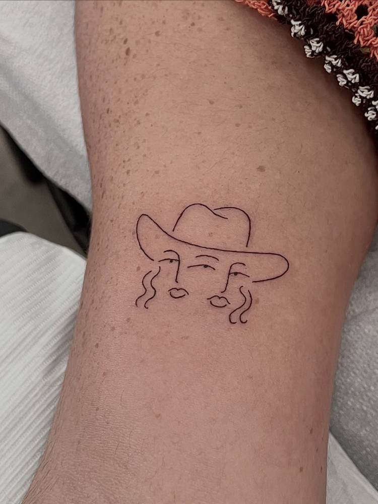 Contemporary style cowgirl portrait tattoo located on the bicep.