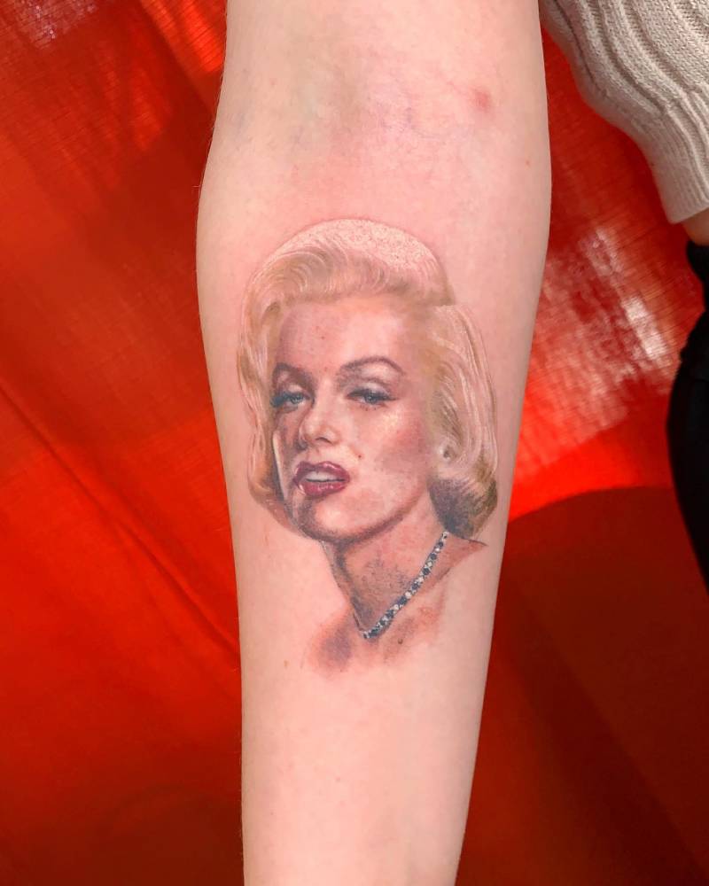 Realistic portrait tattoo of Marilyn Monroe done on the inner forearm.
