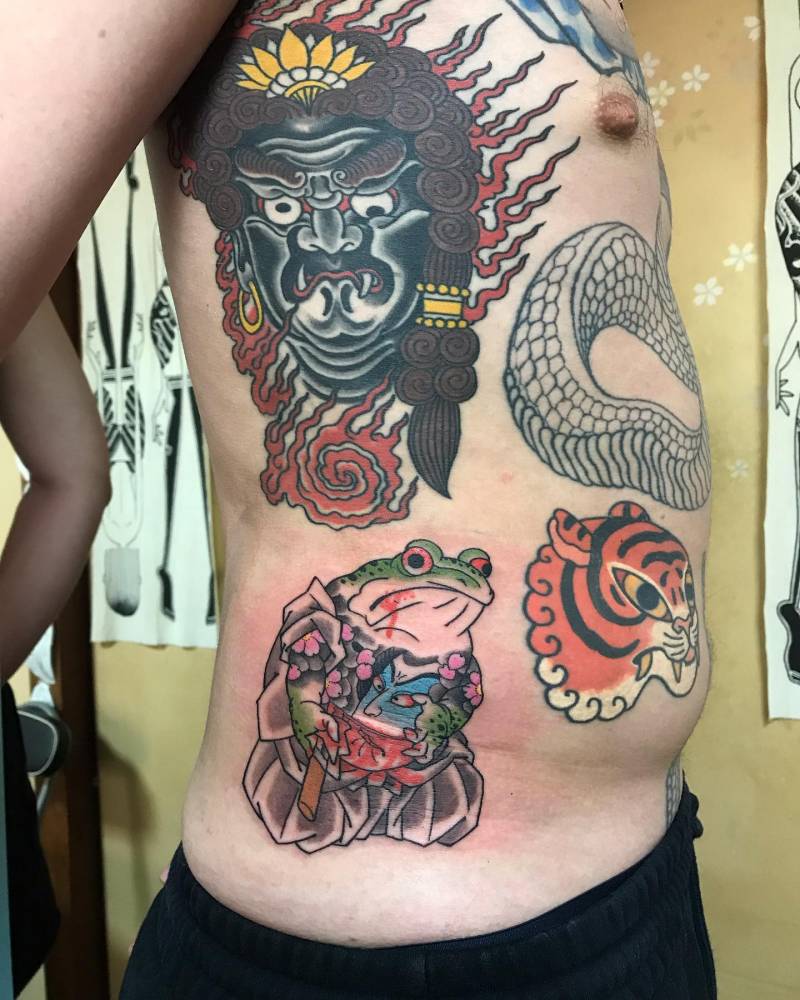 Samurai toad tattoo located on the waist.