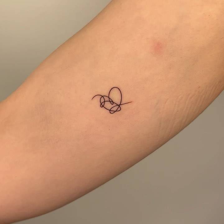 BTS heart tattoo located on the inner forearm.