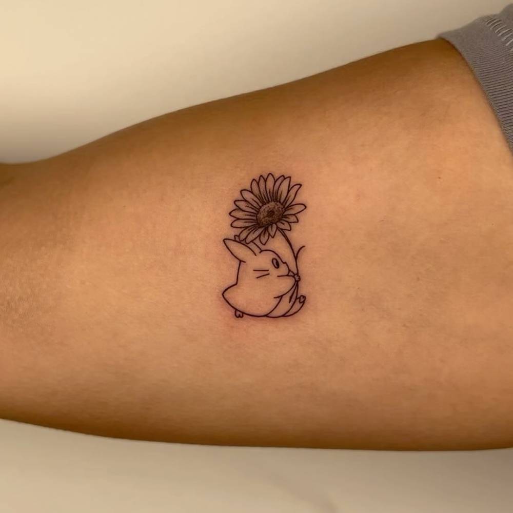 Chuu Totoro and sunflower tattoo located on the inner arm.