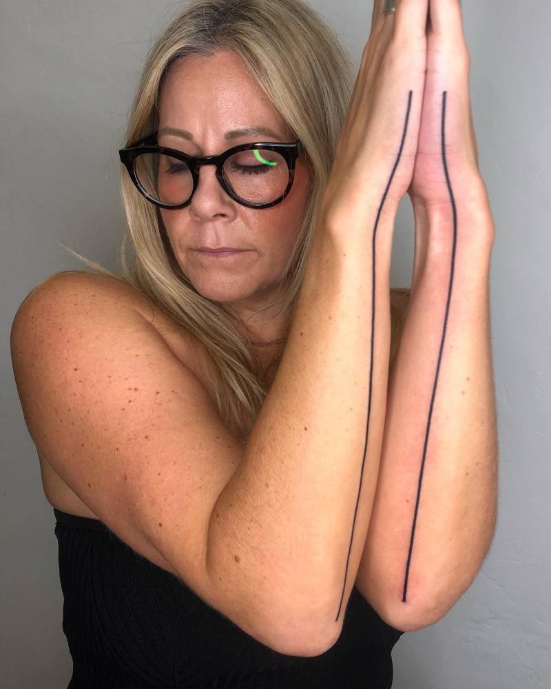 Individual matching lines tattooed on the forearms.