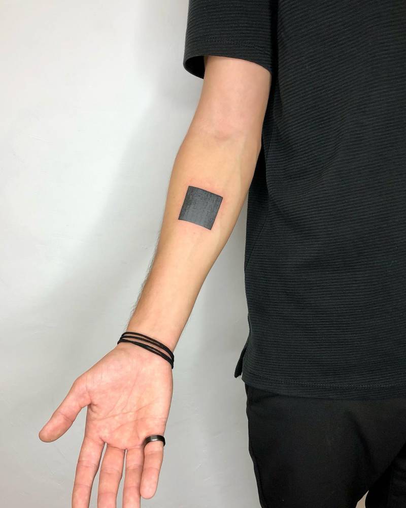 Black square tattoo located on the inner forearm.