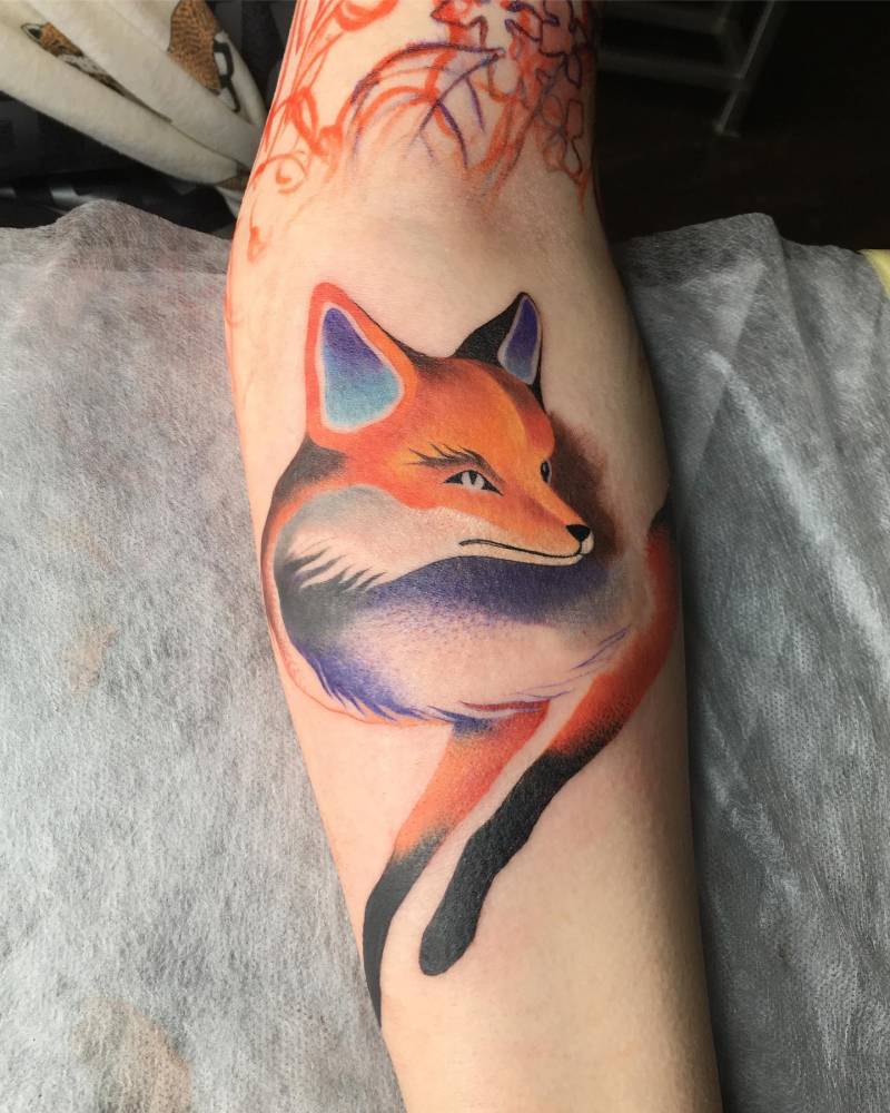 Watercolor style fox tattoo located on the inner forearm.