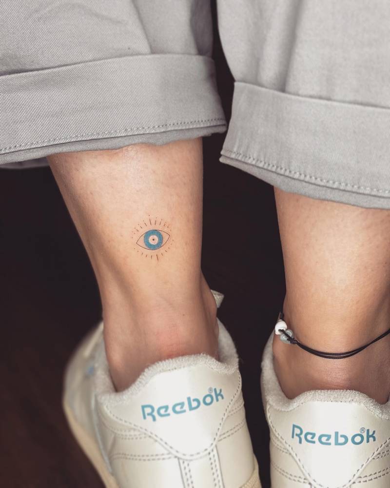 Minimalistic evil eye nazar tattoo located on the achilles.