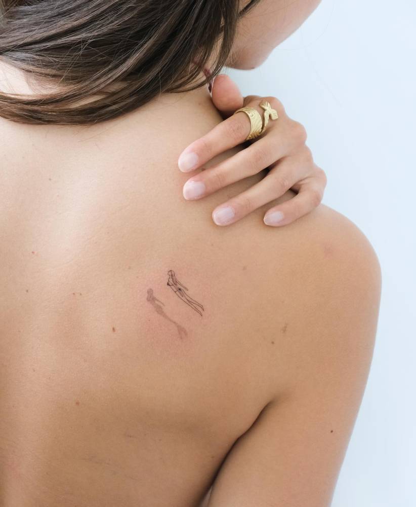 Single needle swimmer tattoo located on the shoulder blade.