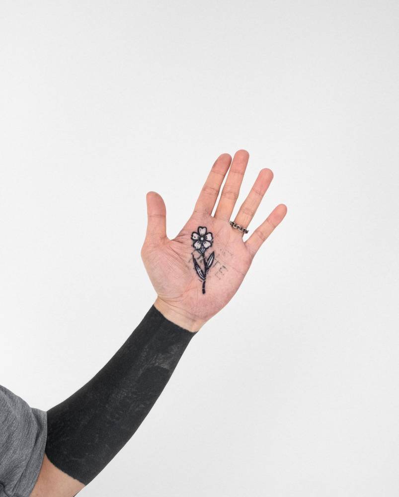 Pop art style flower tattoo located on the palm.