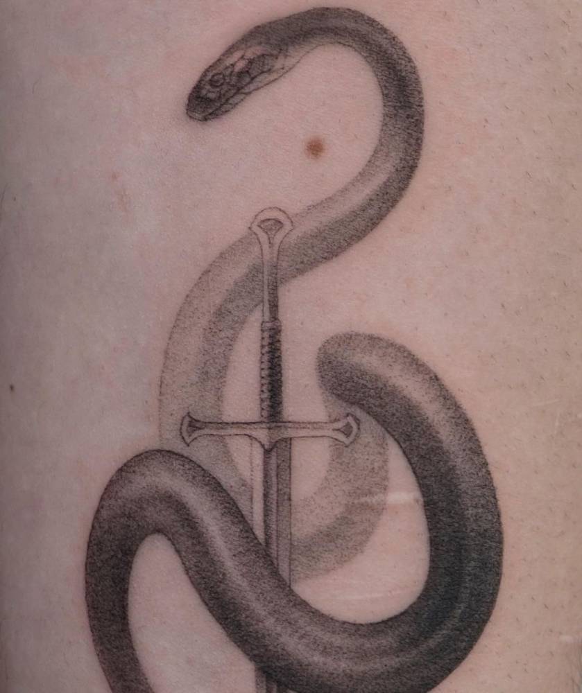 Single needle snake and sword tattoo on the inner forearm