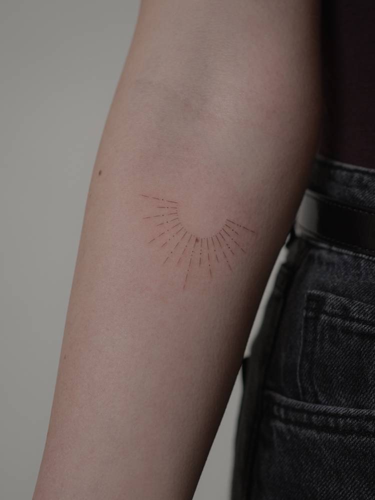 Sunset tattoo in fine line style located on the inner forearm.