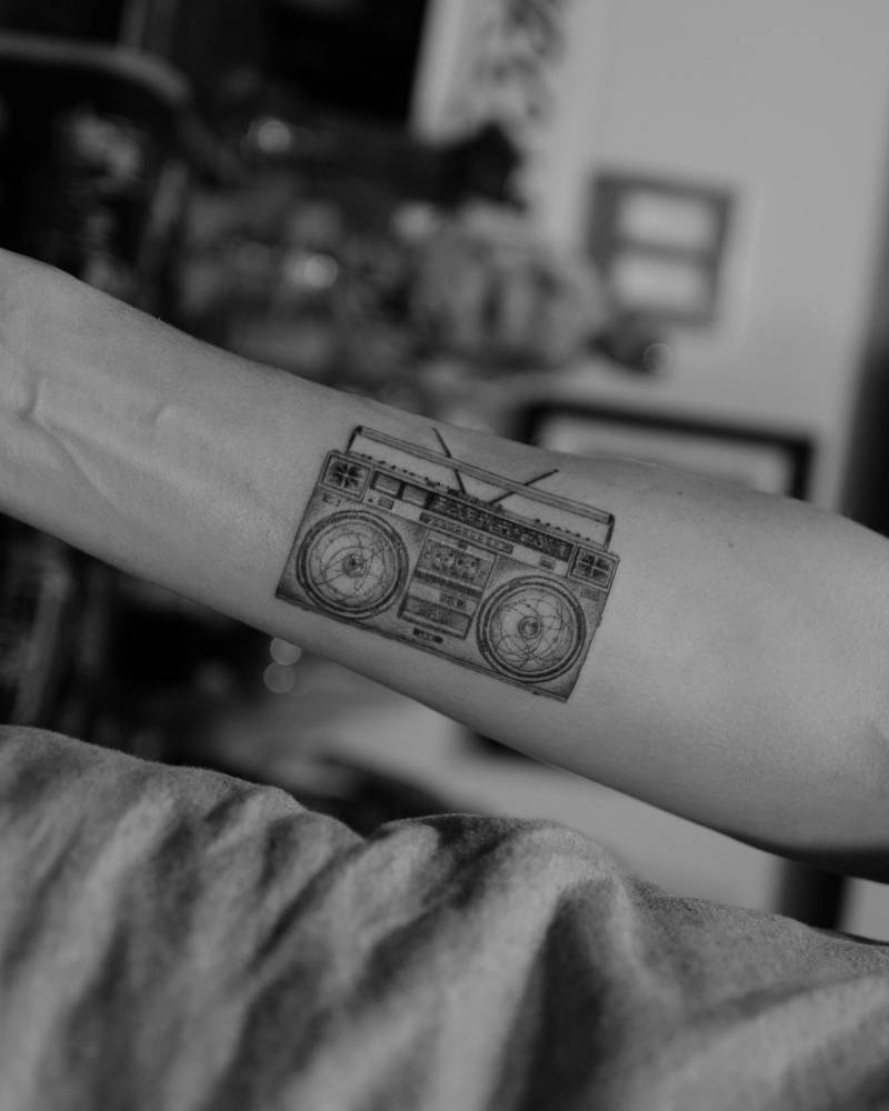 Micro-realistic style boombox tattoo located on the inner forearm.
