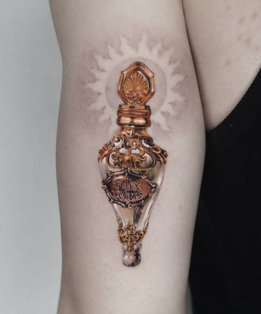 Felix Felicis tattoo in micro-realistic style done on the tricep.