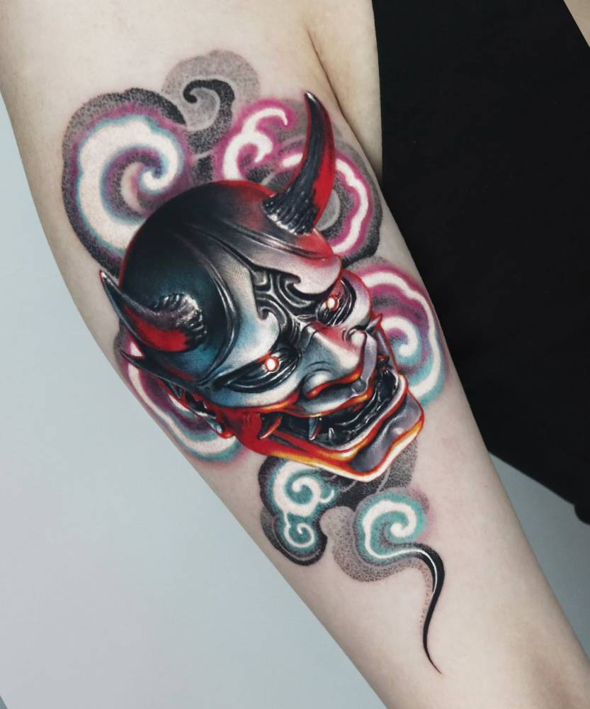 Hannya mask tattoo in realistic style placed on the upper arm.