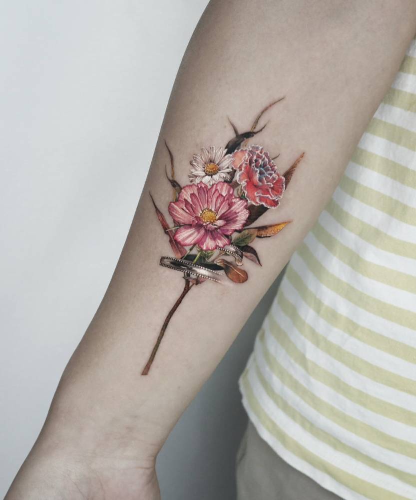 Flower bouquet tattoo in micro-realistic style done on the inner forearm.