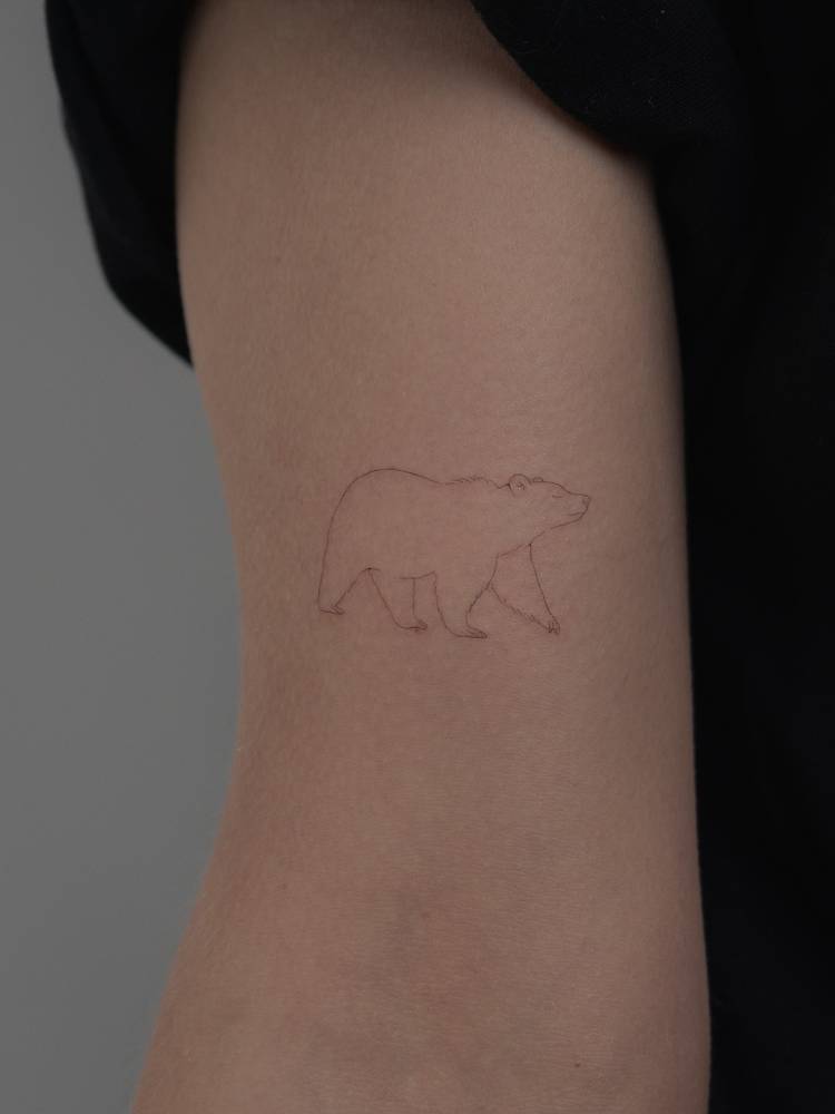 California bear tattoo located on the bicep, fine line style.