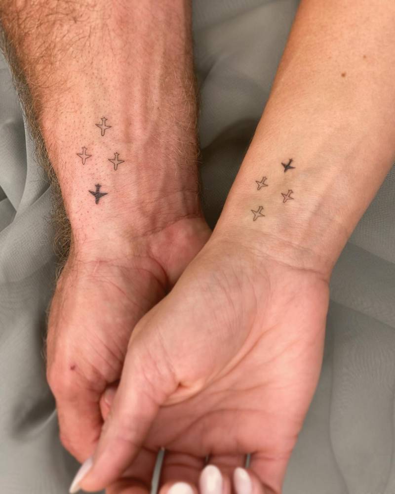 Matching minimalistic planes tattoo for couple.