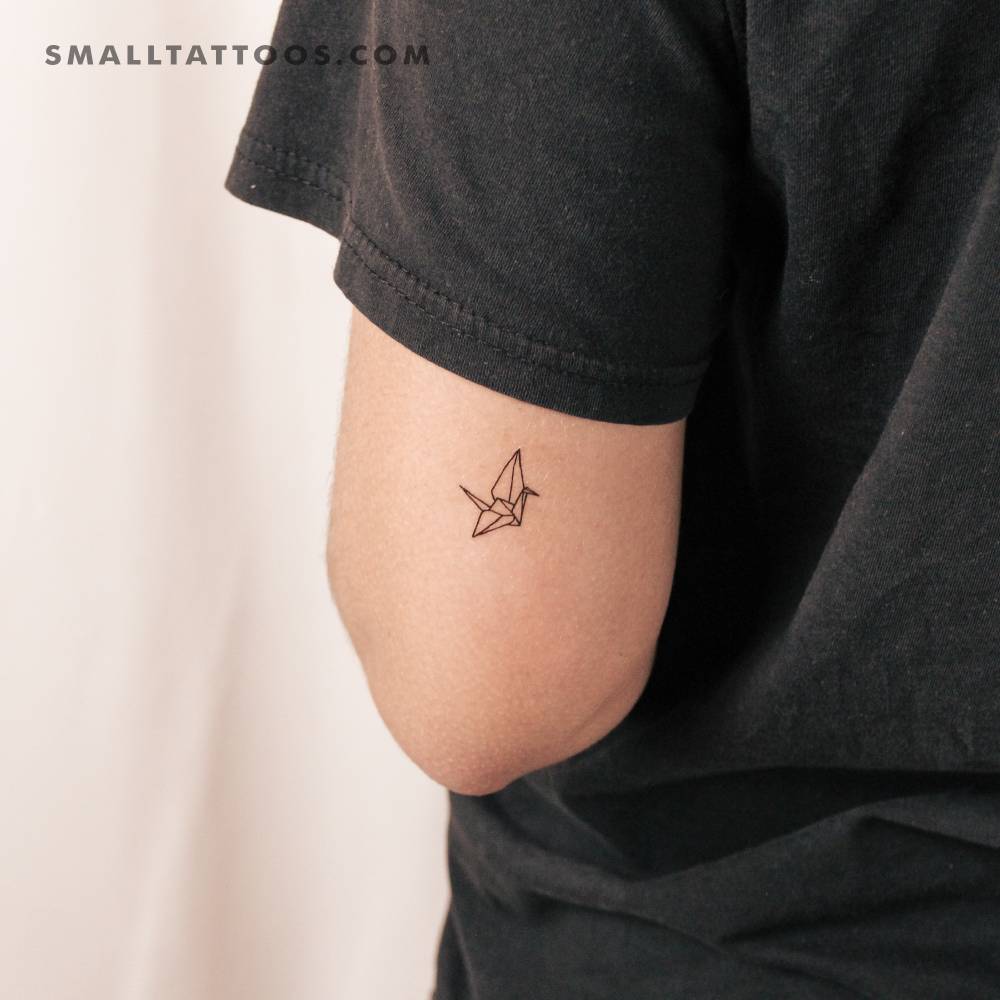 Fine line style orizuru origami crane temporary tattoo located on the tricep.