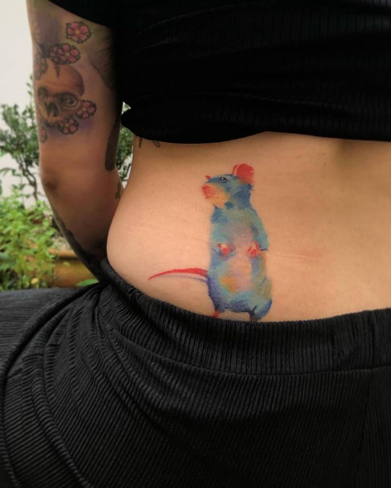 Watercolor style mouse tattoo done on the lower back.