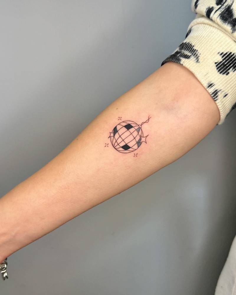 Illustrative style disco ball tattoo located on the inner forearm.