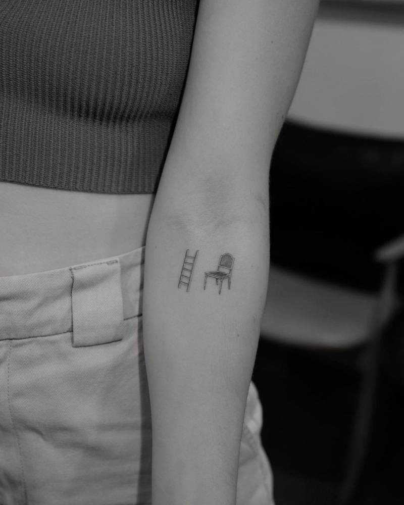 Single needle chair and ladder tattoo located on the inner forearm.