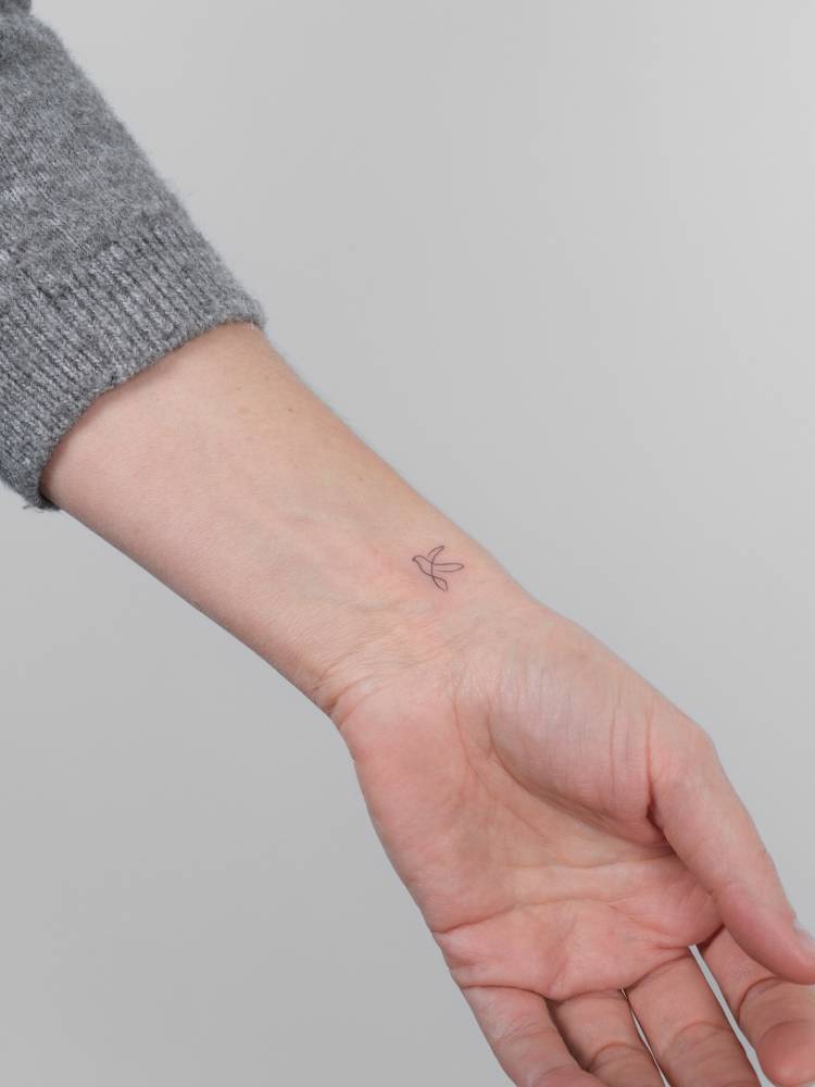 Tiny one line bird tattoo located on the wrist.