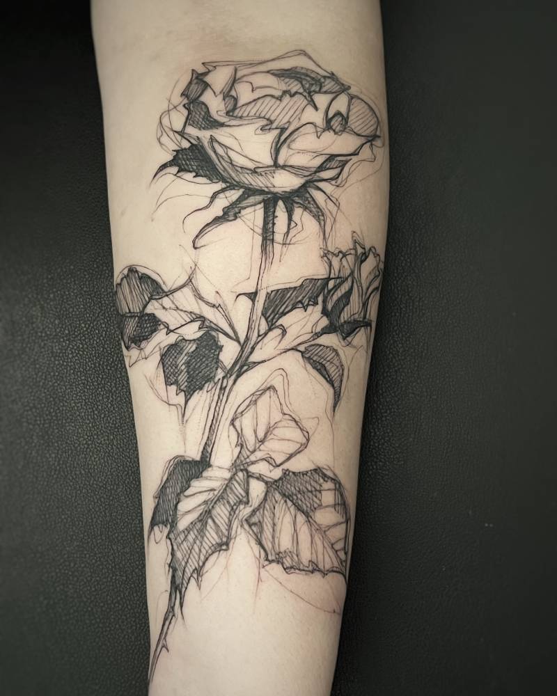 Rose tattoo placed on the inner forearm, sketch work style.