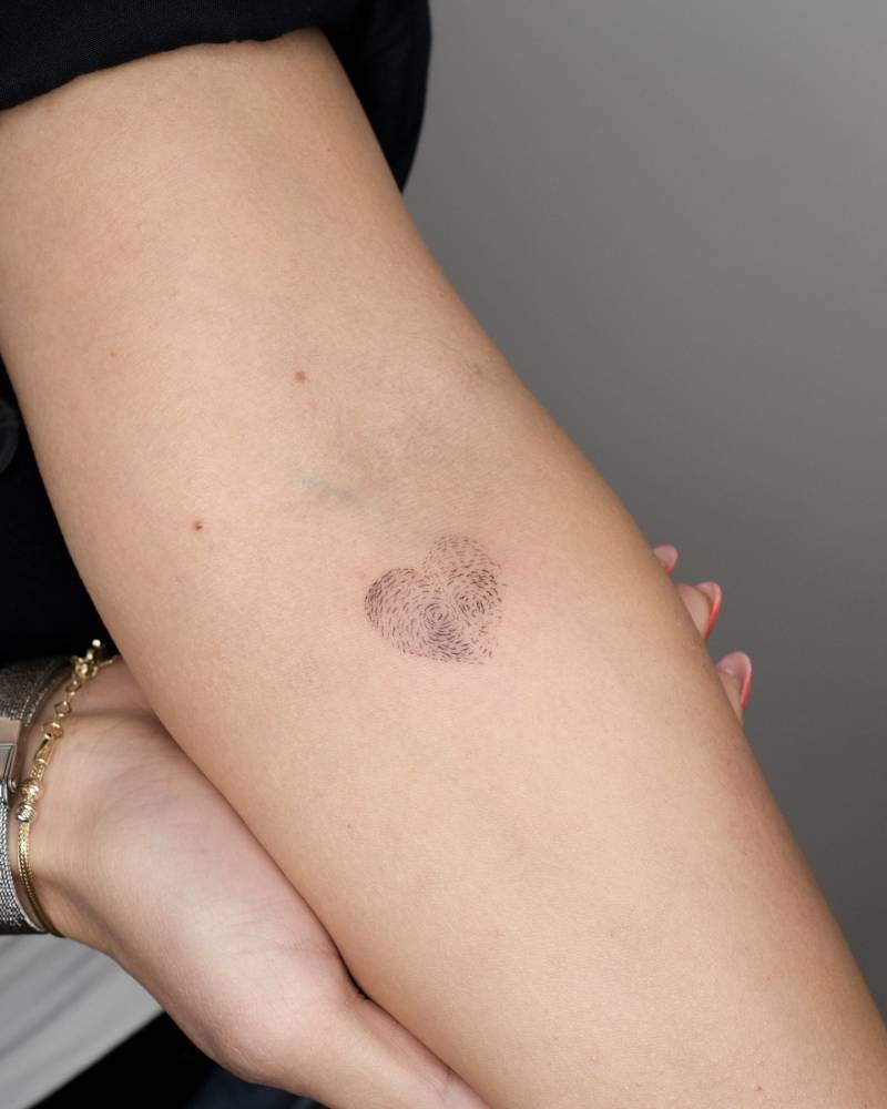 Fingerprint heart tattoo located on the inner forearm.