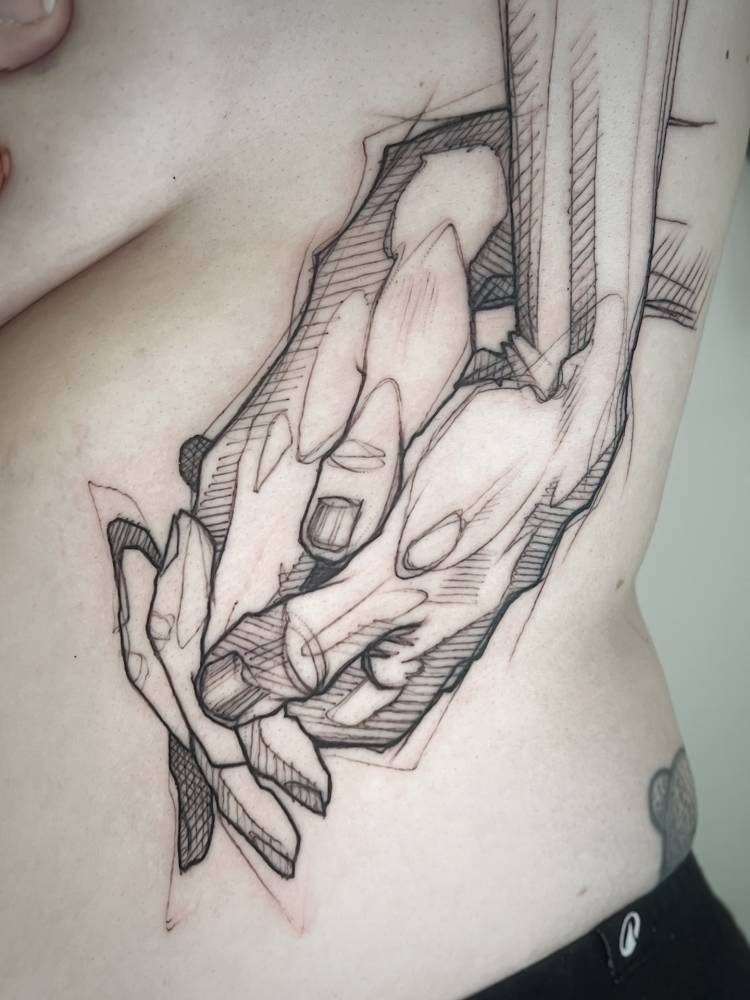Sketch work style holding hands tattoo located on the rib.