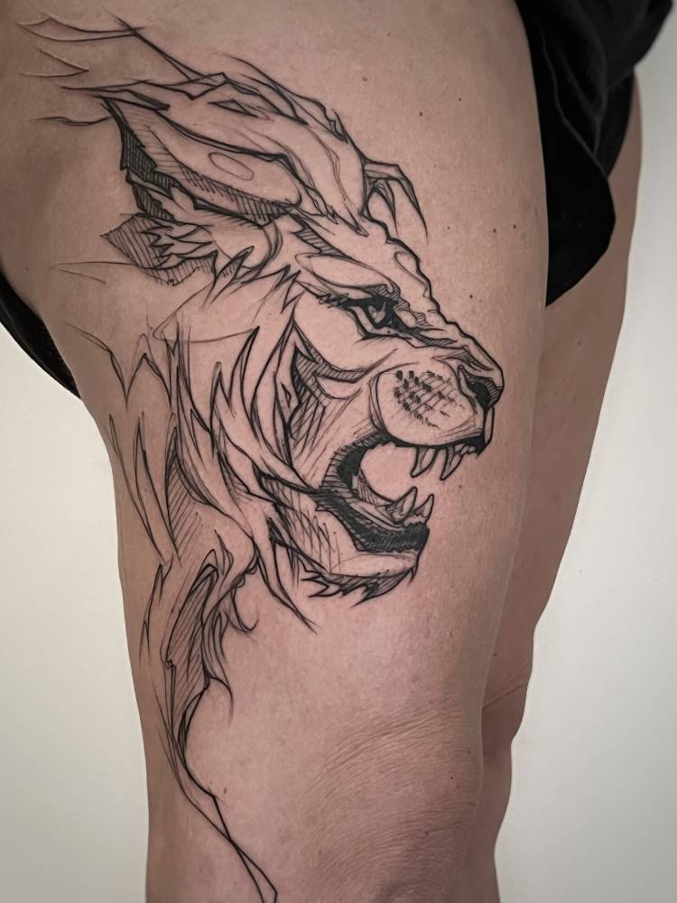 Lion portrait tattoo done on the thigh, sketch work style.