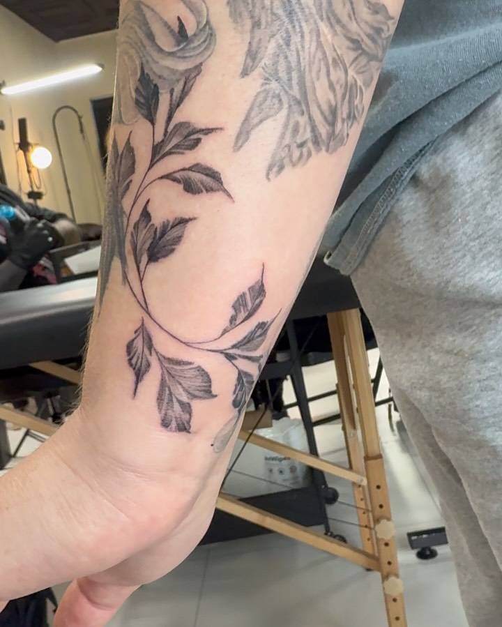 Illustrative style leaves tattoo placed on the wrist.
