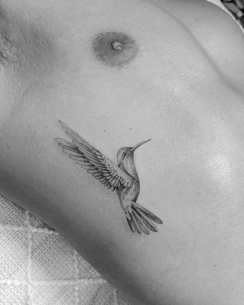 Hummingbird tattoo placed on the rib, micro-realistic style.