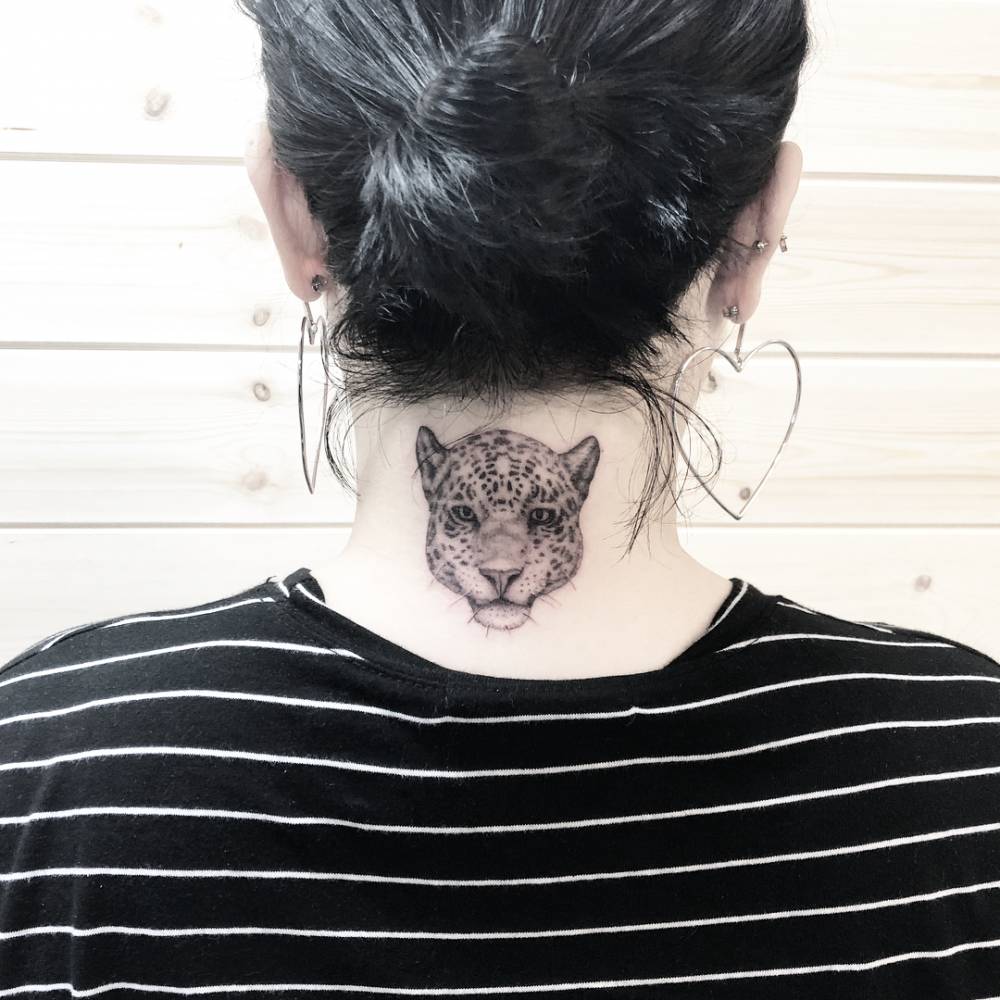 Micro-realistic style jaguar portrait tattoo located on the back of the neck.