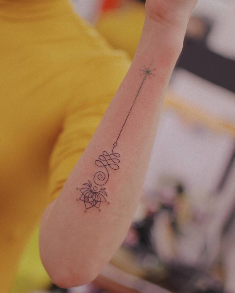 Lotus unalome tattoo located on the forearm.