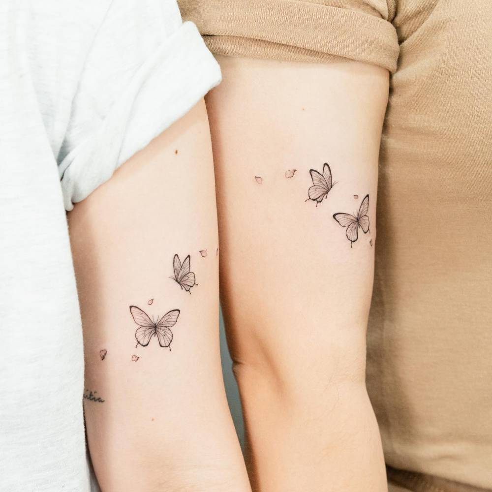 Matching butterfly couple tattoo for sisters.
