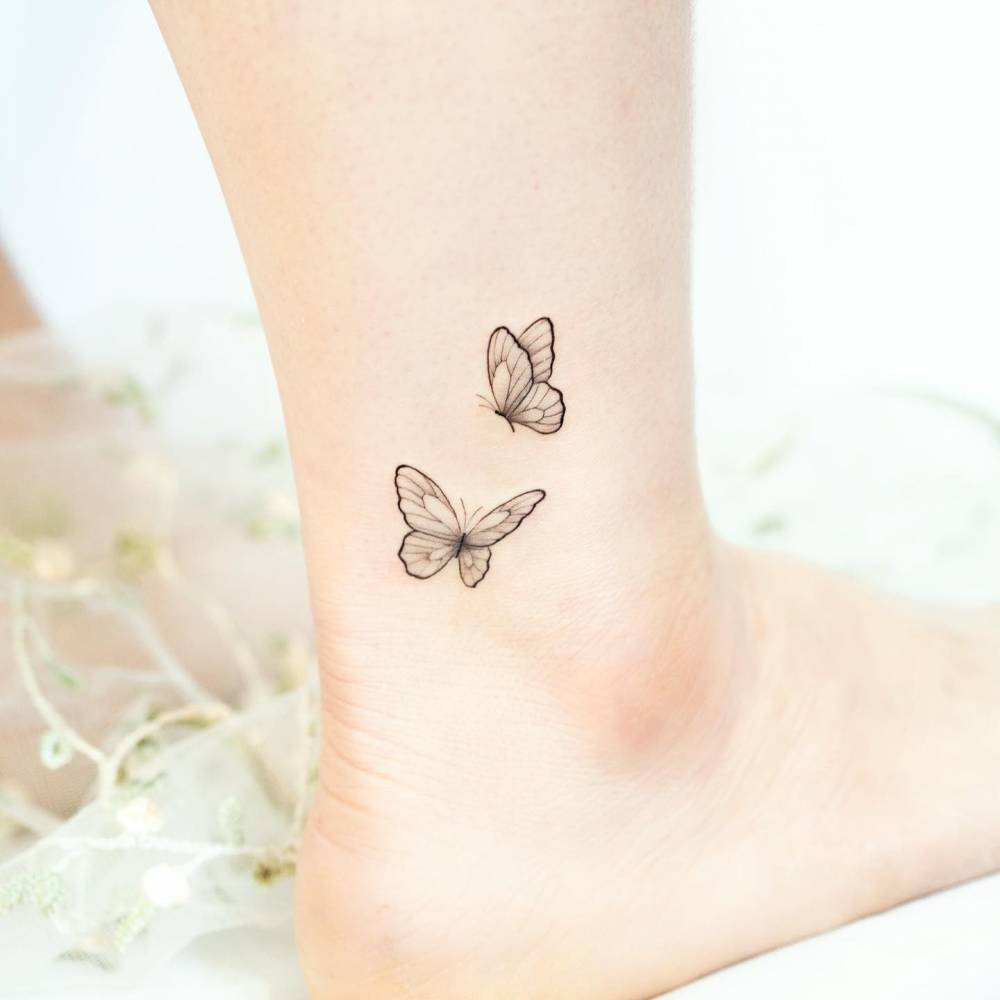 Butterfly couple tattoo located on the ankle, fine line style.